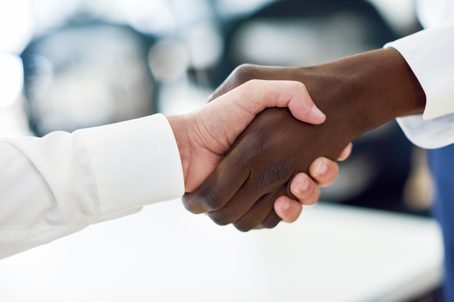 Black businessman shaking hands with a caucasian one